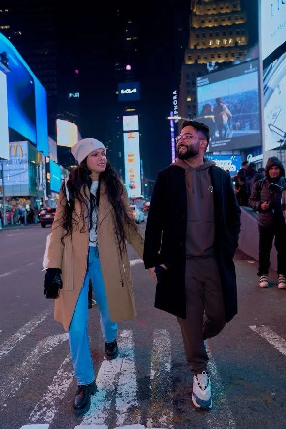 Two creators walking through an illuminated city at night